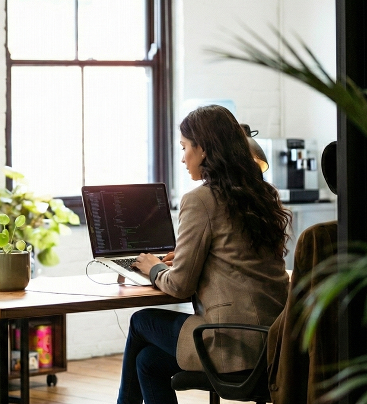 Person working on a laptop in a modern office setting